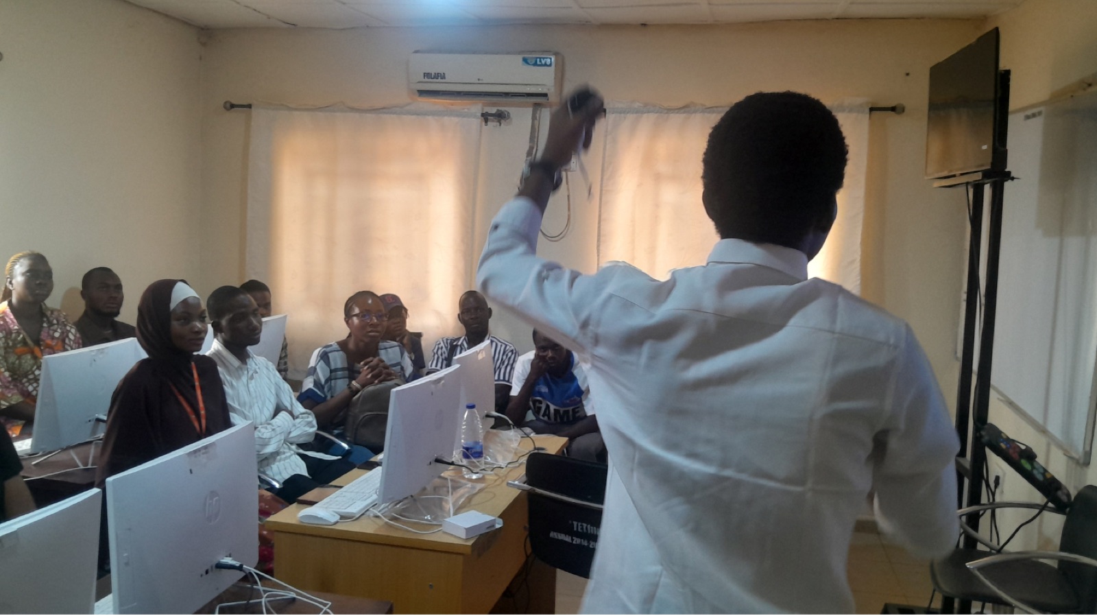 A facilitator demonstrating a VR controller to a seated group