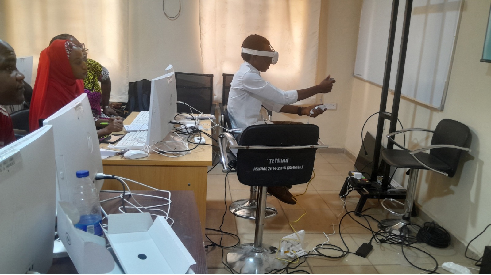 A seated participant using a VR headset and hand controllers