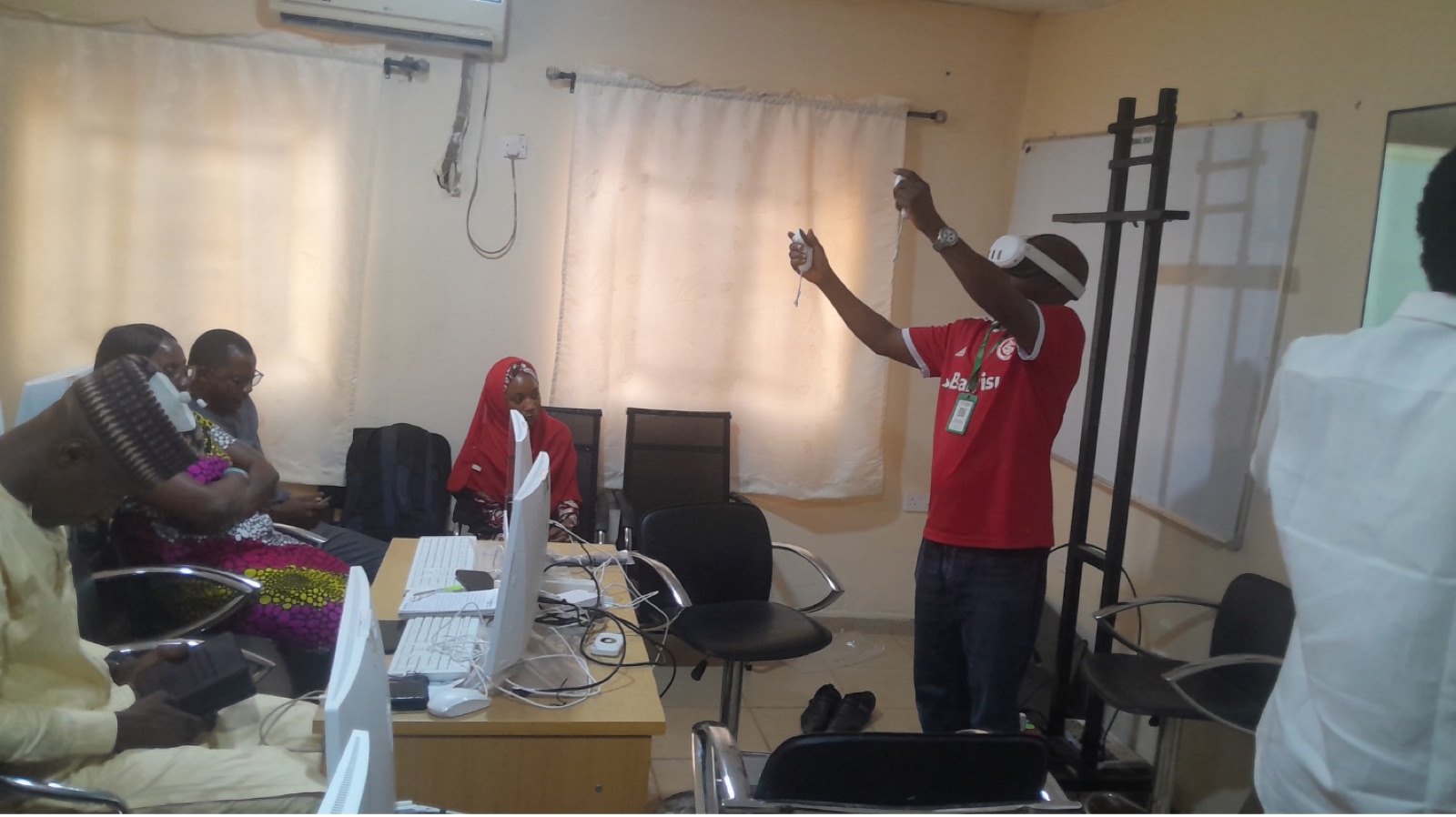 A participant in a VR headset reaching up during a simulation